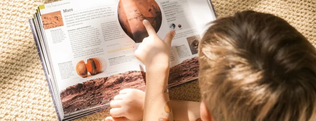 kind liest ein buch ueber mars